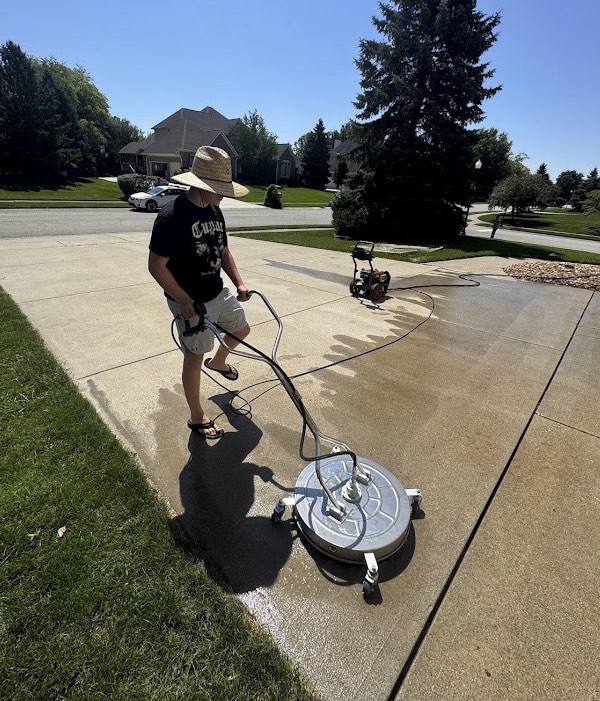 Hahn Power Wash pressure washing a concrete driveway in Carmel, IN with a professional surface cleaner
